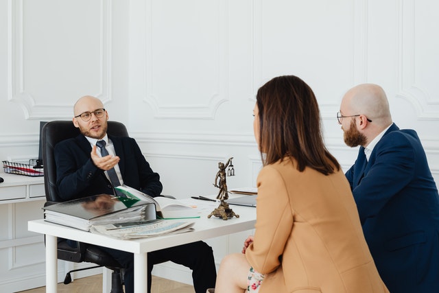 Couple sitting across the table from a bankruptcy specialist and talking about reasons for a bankruptcy denial.