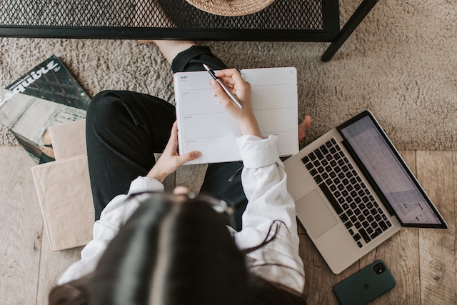 A girl with a pen and notebook in her hands