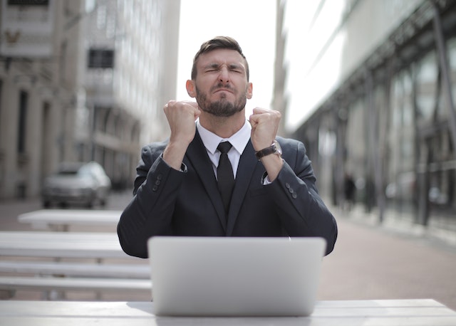 Man in a suit being happy for his business.