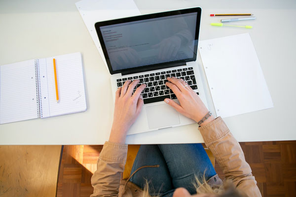 A woman researching on her laptop how to reduce her credit score